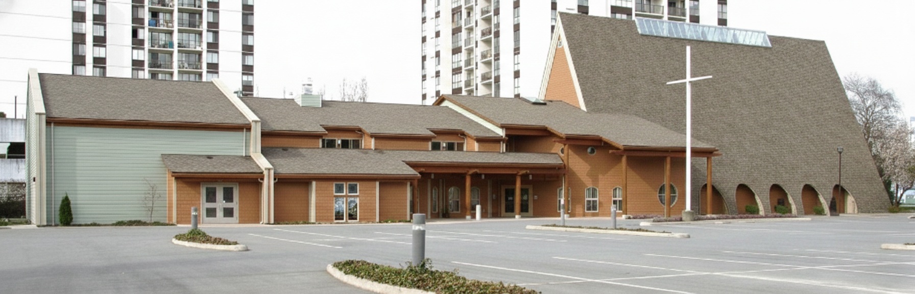 Exterior view of the completed two-storey, 18,300 square foot multiuse facility at Trinity Lutheran Church in Richmond, BC, in 2003. The addition connects to the main sanctuary, providing a seamless connection to a large narthex, parish hall, classrooms, and offices. The church was also renovated and a new skylight installed along the roof ridge of the iconic A-frame building as part of the project.